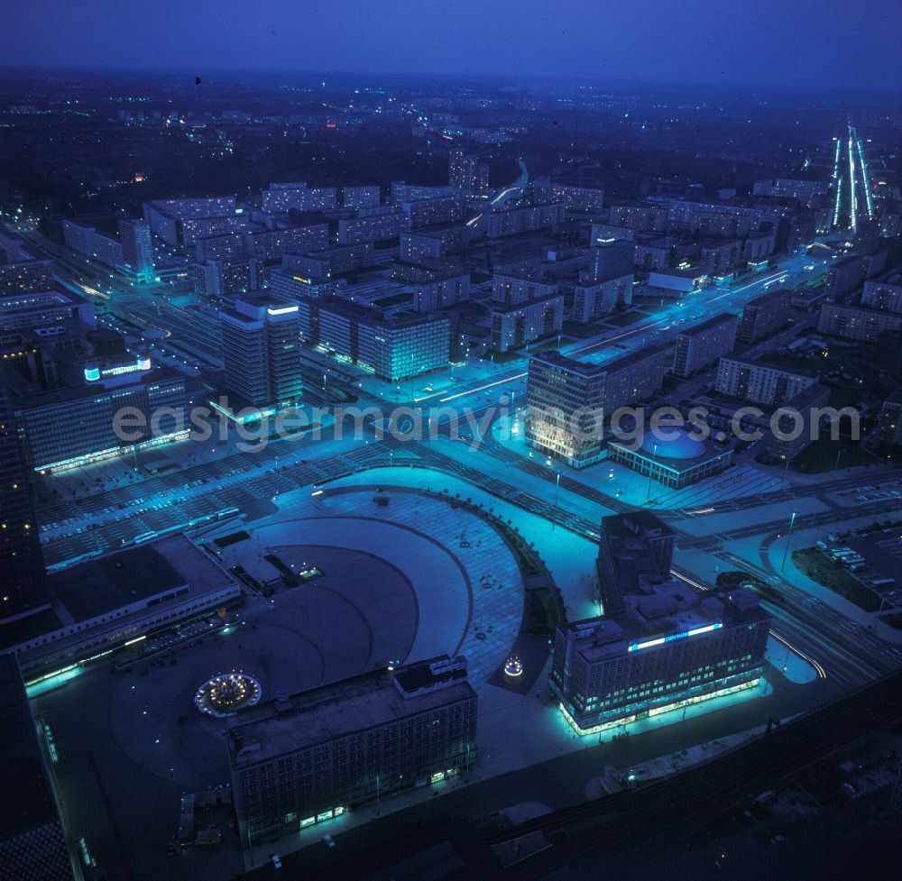 Aerial image at night Berlin - Alexanderplatz illuminated at night with the Hotel Stadt Berlin , the Fountain of Friendship, the “ Haus der Statistik “, the “ Haus des Lehrers “ and the Congress Hall in Berlin, the former capital of the GDR, German Democratic Republic, east Germany