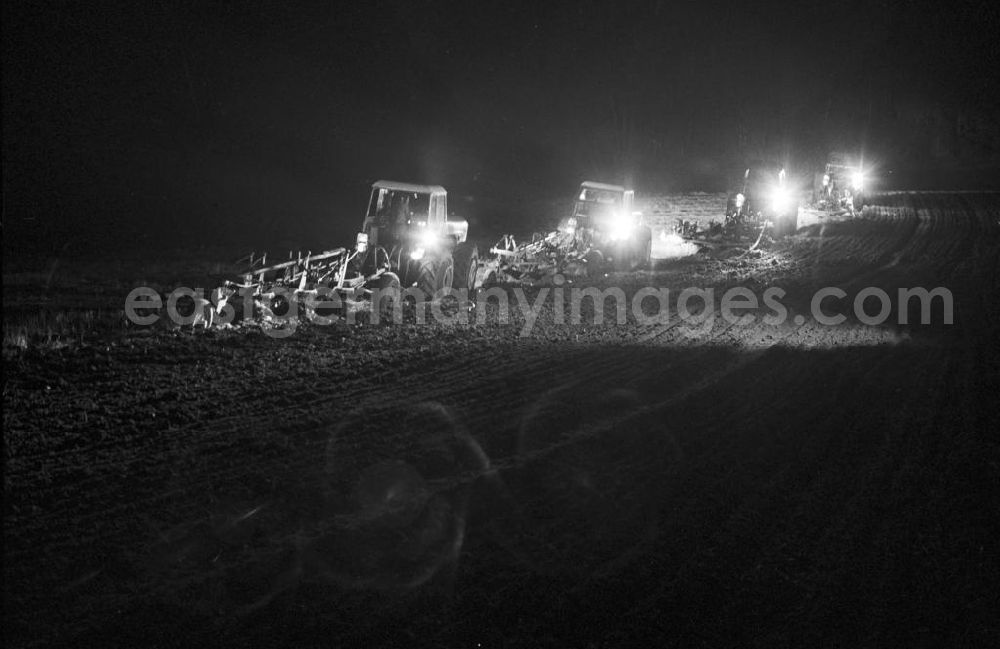 Aerial photograph at night Wilmersdorf - Nachtaufnahme: Schichtarbeit im Volksgut Wilmersdorf (Kreis Angermünde). Traktoren mit Pflug beim Pflügen eines Feldes.