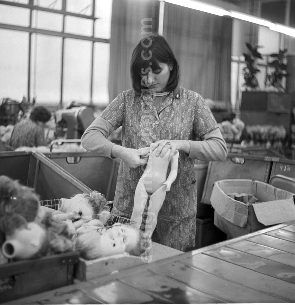 GDR picture archive: Sonneberg - Eine Mitarbeiterin des VEB Kombinat Spielwaren Sonneberg sonni setzt einem Puppenkörper die Arme ein. Die Sonneberger Puppen waren nicht nur in der DDR beliebt, sondern trugen den Namen der Stadt in alle Welt.