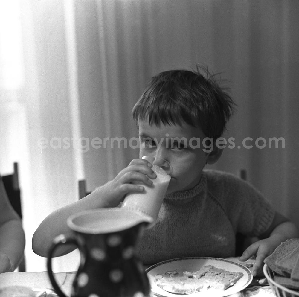 GDR photo archive: Berlin - Zwei Tage im Leben einer alleinerziehenden Frau mit zwei Kindern in Ostberlin. Zwischen Privatem, Arbeit und Weiterbildung ( EDV Kurs ). Die Familie sitzt am Tisch und ißt Abendbrot, ein Mädchen trinkt Milch aus einem Glas.