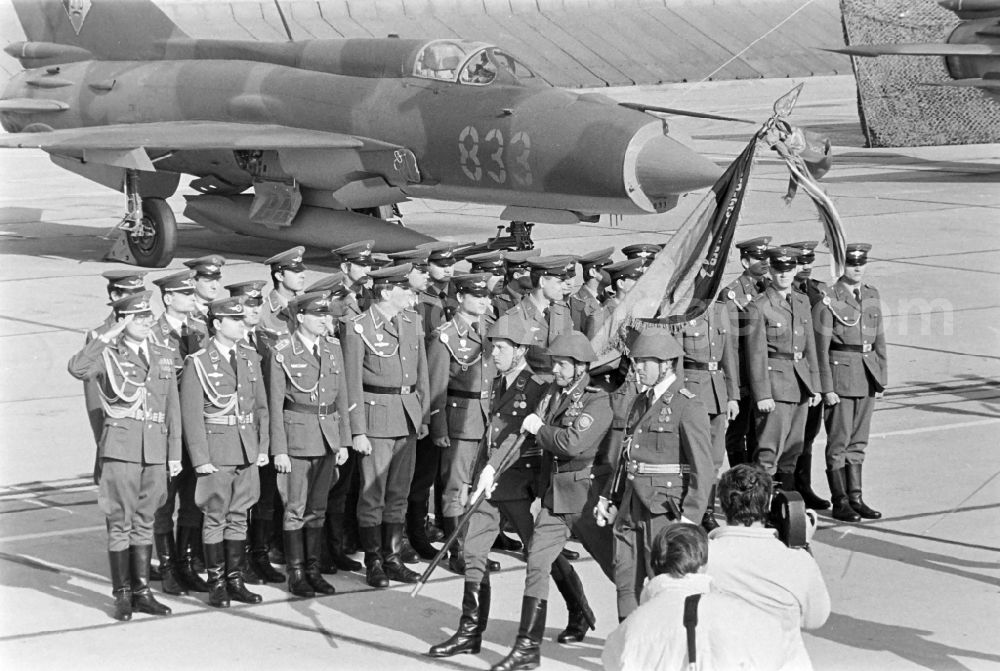 GDR photo archive: Jänschwalde - Media-effective passage of the honorary formation of the flag command of troops from the fighter squadron Wilhelm Pieck of the air force at the pre-launch line of the stationed MiG-21 PFM weapon system as part of a disarmament action at the Drewitz airfield of the National People's Army NVA office in Jaenschwalde in the state of Brandenburg on the territory of the former GDR, German Democratic Republic