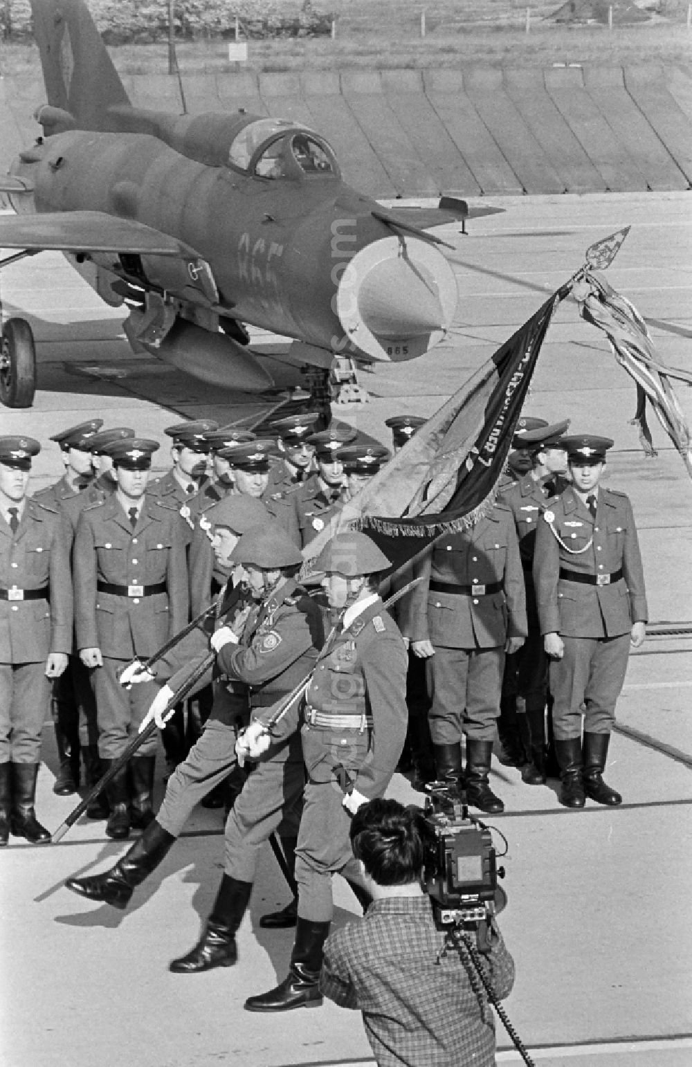 GDR image archive: Jänschwalde - Media-effective passage of the honorary formation of the flag command of troops from the fighter squadron Wilhelm Pieck of the air force at the pre-launch line of the stationed MiG-21 PFM weapon system as part of a disarmament action at the Drewitz airfield of the National People's Army NVA office in Jaenschwalde in the state of Brandenburg on the territory of the former GDR, German Democratic Republic