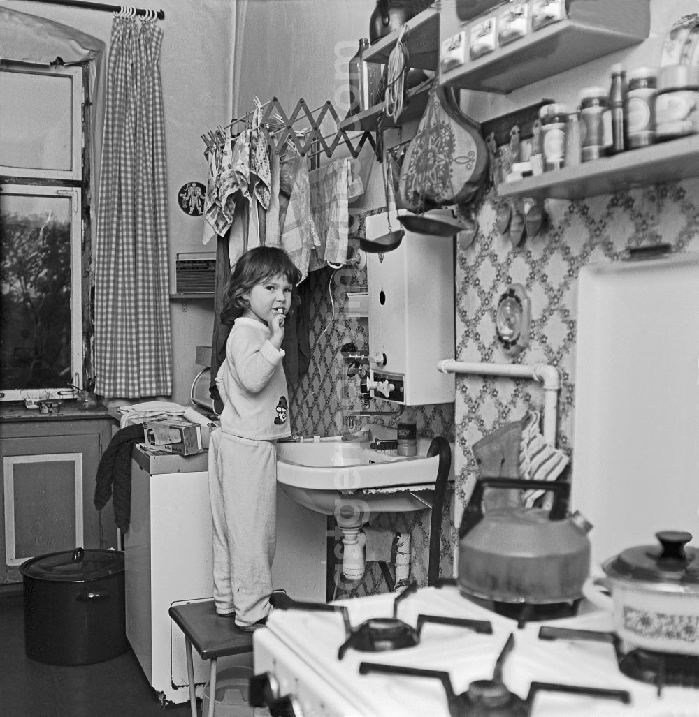 Berlin: Toddler brushing his teeth on a stool in front of the sink in a kitchen in an old residential building with a toddler brushing his teeth on Moissistrasse in the Treptow district of Berlin East Berlin in the area of ??the former GDR, German Democratic Republic