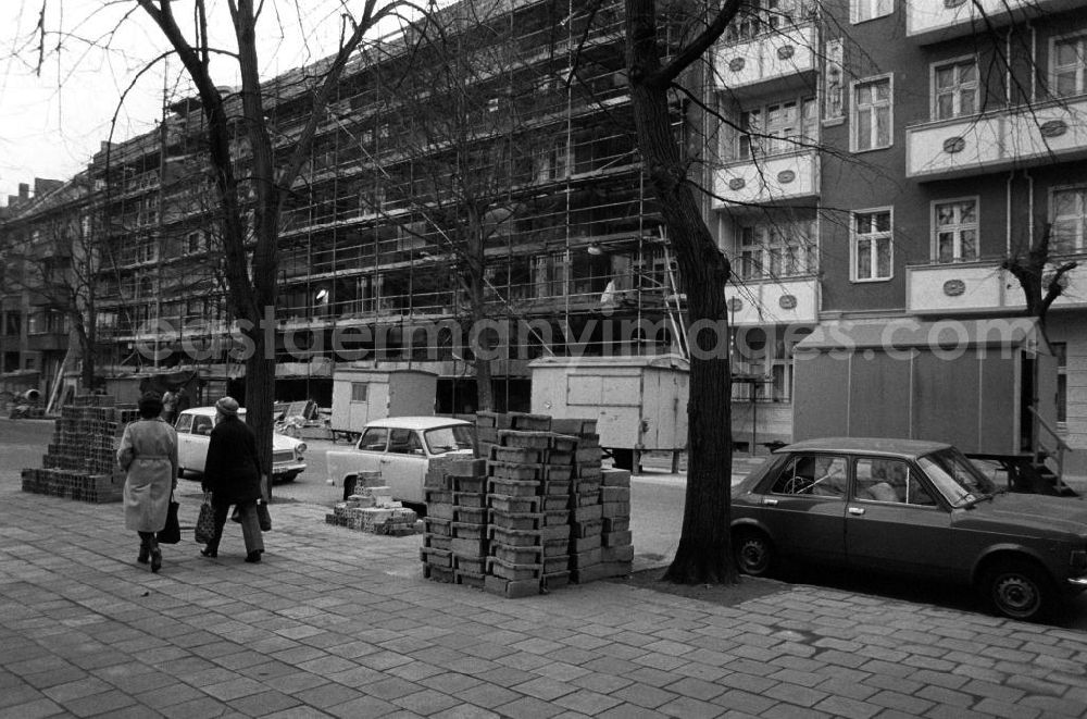 GDR picture archive: Berlin - Baugerüste an Wohnhäusern in der Britzer Straße in Niederschöneweide. Arbeiter bei der Sanierung von Altbau-Wohnhäusern. Baumaterial auf Fußweg gestapelt. Bauwagen stehen am Straßenrand. Autos vom Typ Trabant 601 und Zastava 110