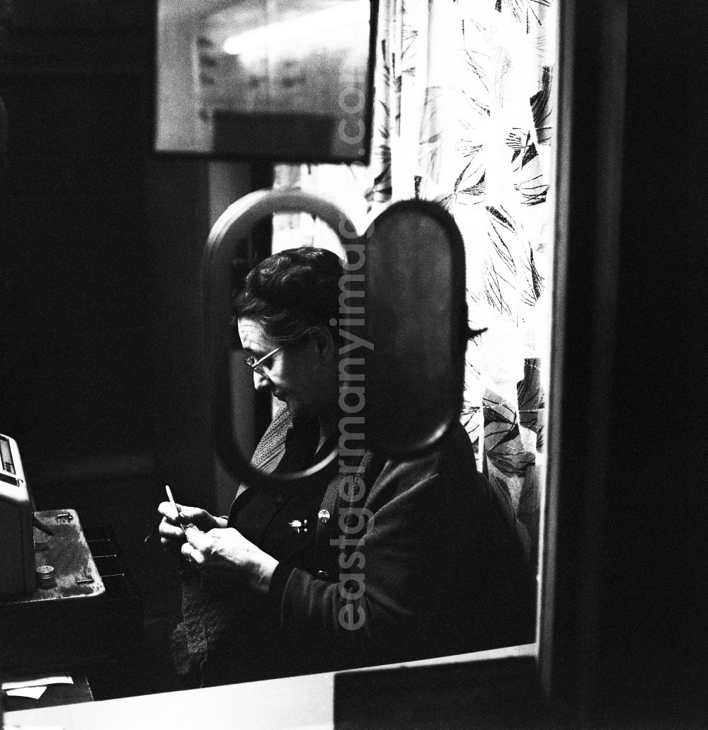 GDR image archive: Berlin - Lichtenberg - An elderly woman sitting in a funicular ticket office and embroiders in Berlin - Lichtenberg