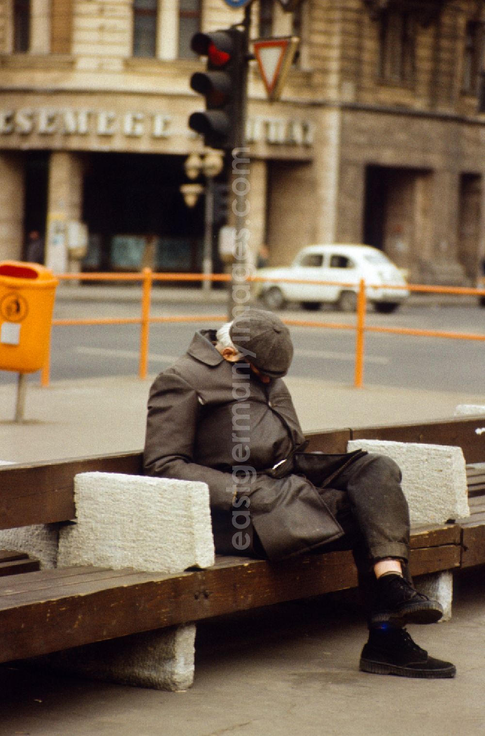 Berlin: Old man sleeping on a street bench in East Berlin on the territory of the former GDR, German Democratic Republic