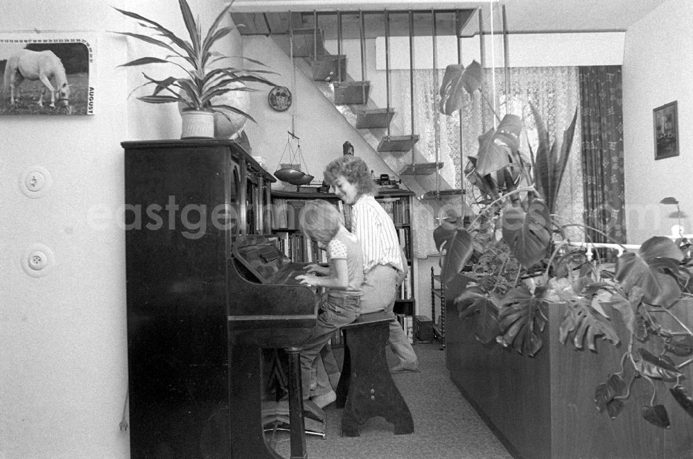 GDR picture archive: Dresden - Child playing the piano and interior design of an apartment in Dresden in the state Saxony on the territory of the former GDR, German Democratic Republic