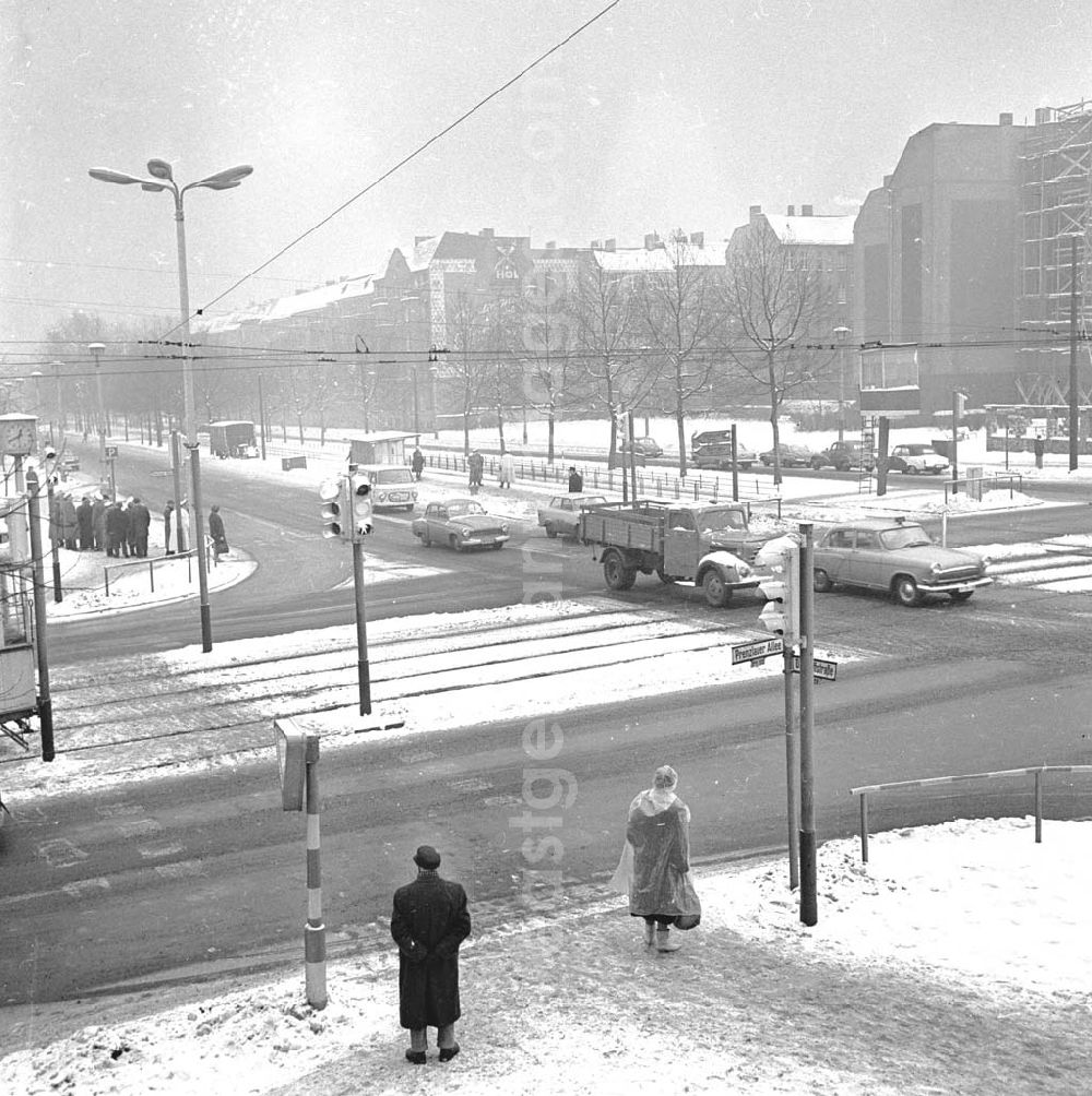 GDR picture archive: Berlin - Neue automatische Verkehrssignalanlage an der Kreuzung Dimitroffstrasse Ecke Prenzlauer Allee, Autos fahren winterlich mit Schnee bedeckte Strasse entlang.