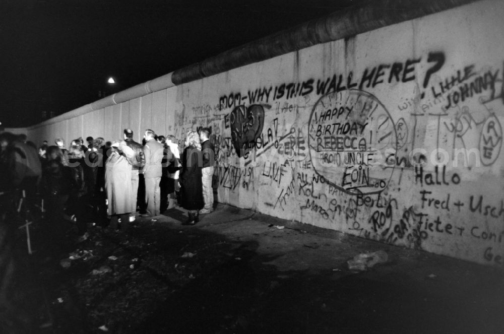 GDR picture archive: Berlin - People stand together at the wall on the West Berlin side. The wall is covered in graffiti, including the words mom-why is this wall here?