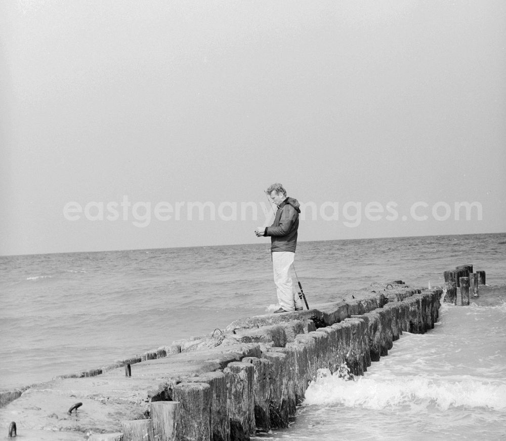 GDR image archive: Ahrenshoop - An angler on a stage at the Baltic Sea in Ahrenshoop in the federal state Mecklenburg-Western Pomerania on the territory of the former GDR, German Democratic Republic
