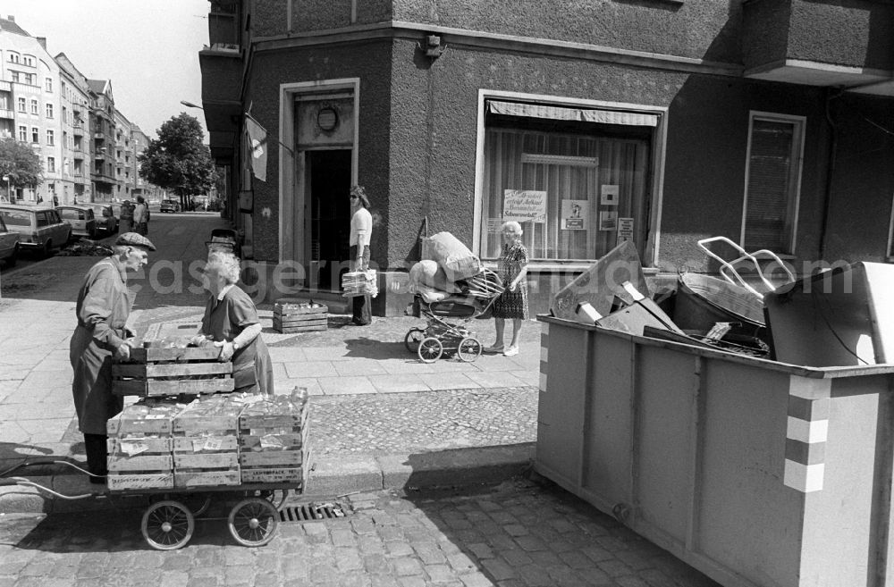 GDR image archive: Berlin - With carts and old strollers, older local residents bring empty bottles and glasses as well as waste paper to a collection point for waste materials in the Schreinerstrasse in Berlin-Friedrichshain