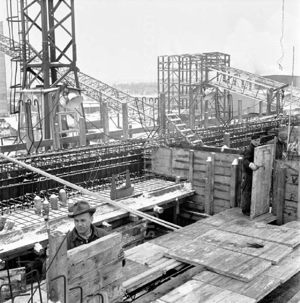 GDR picture archive: Guben - Arbeiter auf verschneiter Baustelle am VEB Chemiefaserwerk Herbert Warnke Guben.