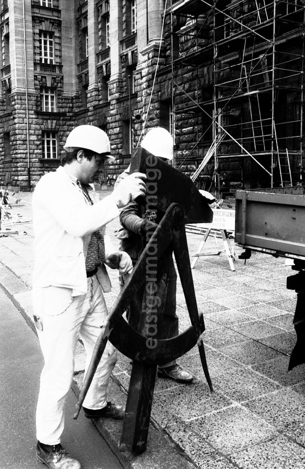 GDR image archive: Berlin-Mitte - Arbeiter demontieren das Arbeitersymbol - Abbau des DDR-Emblemes am berliner Stadthaus - dem damaligen Sitz des Magistrates der Hauptstadt der DDR.