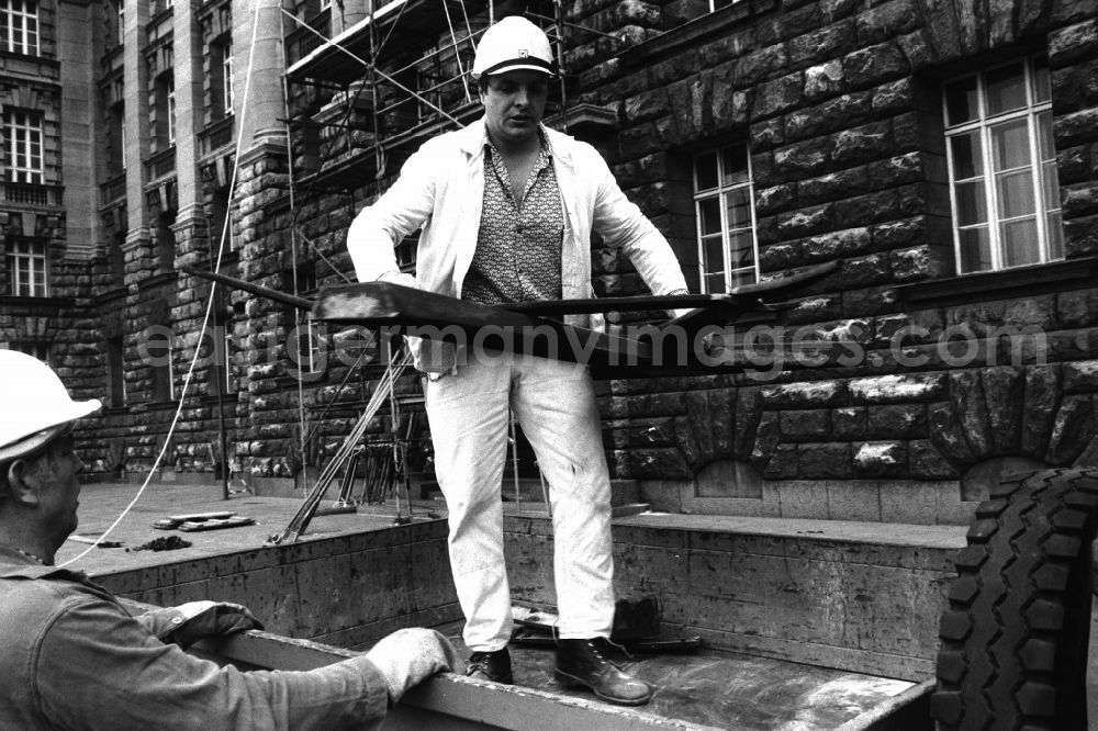 GDR photo archive: Berlin - Dismantling of the GDR symbol, consisting of a hammer and compass, from the facade of the Berliner Stadthaus (Former Council of Ministers of the GDR) in Berlin-Mitte, the former capital of the GDR, German Democratic Republic