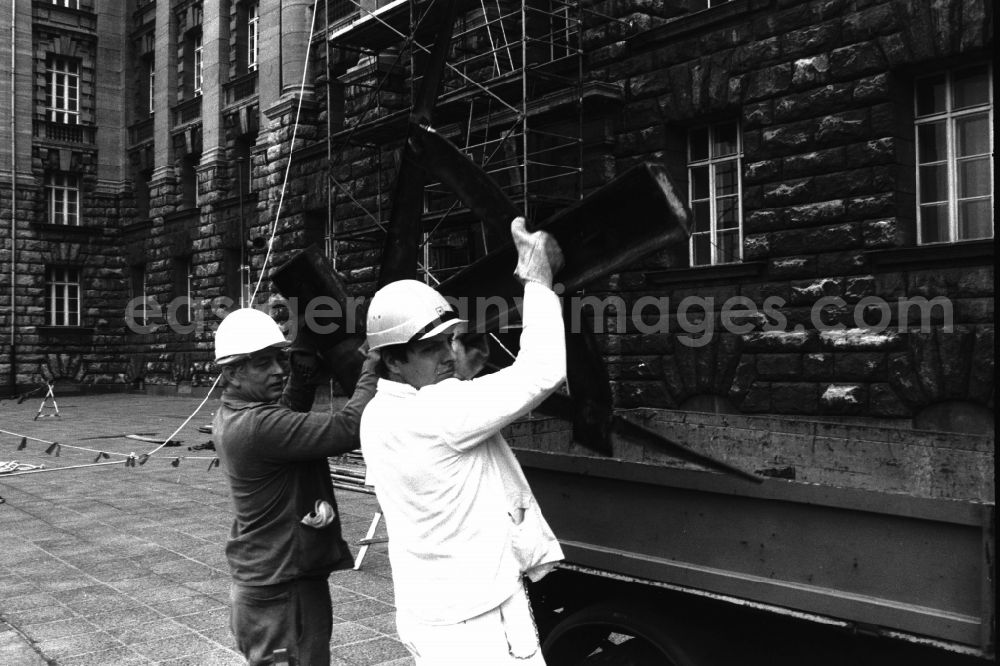 GDR photo archive: Berlin - Dismantling of the GDR symbol, consisting of a hammer and compass, from the facade of the Berliner Stadthaus (Former Council of Ministers of the GDR) in Berlin-Mitte, the former capital of the GDR, German Democratic Republic