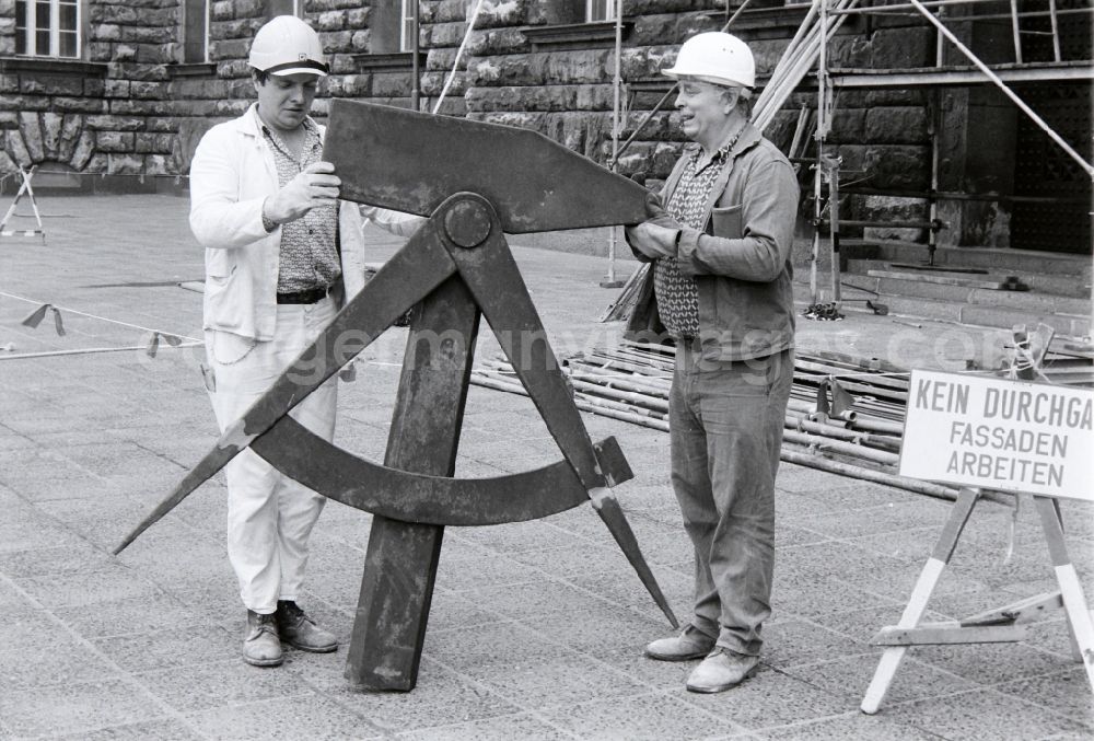 GDR photo archive: Berlin - Workers remove the worker symbol at the Berliner Stadthaus of the former capital of the GDR, German Democratic Republic