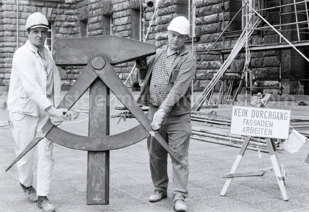 GDR picture archive: Berlin - Workers remove the worker symbol at the Berliner Stadthaus of the former capital of the GDR, German Democratic Republic