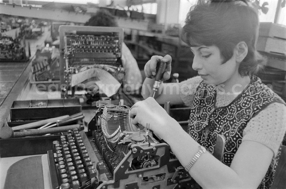 GDR photo archive: Erfurt - A young worker working with a typewriter in the VEB Optima Bueromaschinenwerk Erfurt in Thuringia