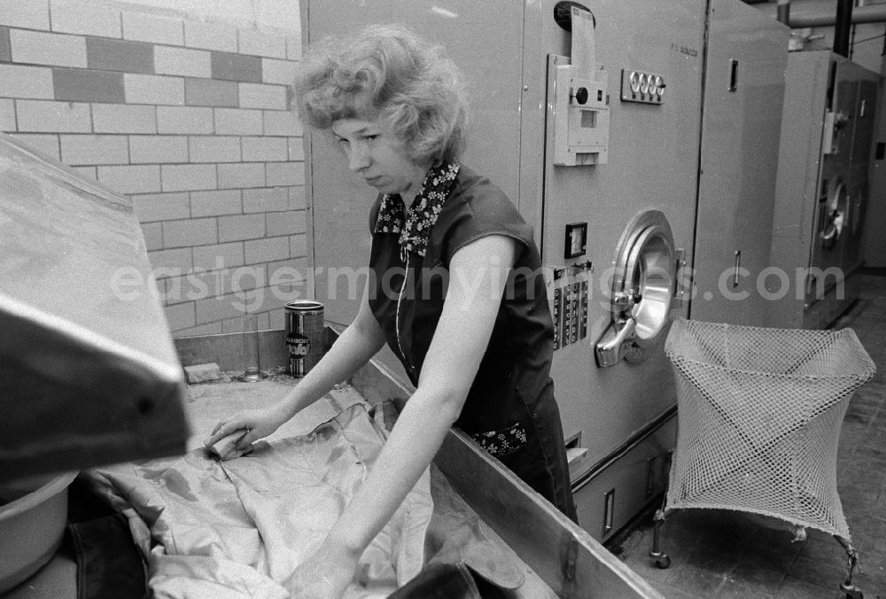 GDR image archive: Berlin - A worker in the VEB united laundrys Berlin Rewatex with clean of a coat in Berlin, the former capital of the GDR, German democratic republic