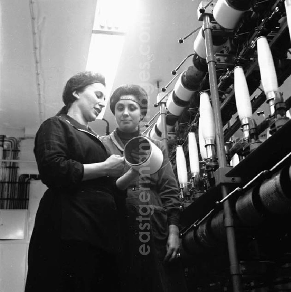 GDR image archive: Guben - Zwei Arbeiterinnen betrachten aufgerolltes Garn auf Spule im VEB Chemiefaserwerk Herbert Warnke Guben.