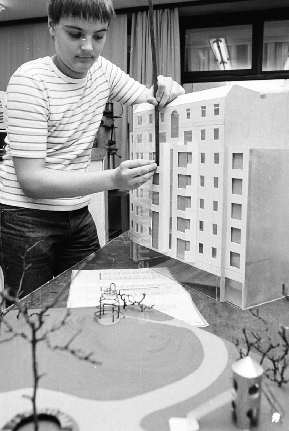 GDR picture archive: Berlin - Arbeitsgemeinschaft Modellbau im Pionierpalast Ernst Thälmann in der Wuhlheide. Junge / Kind an Modellhaus beim messen.