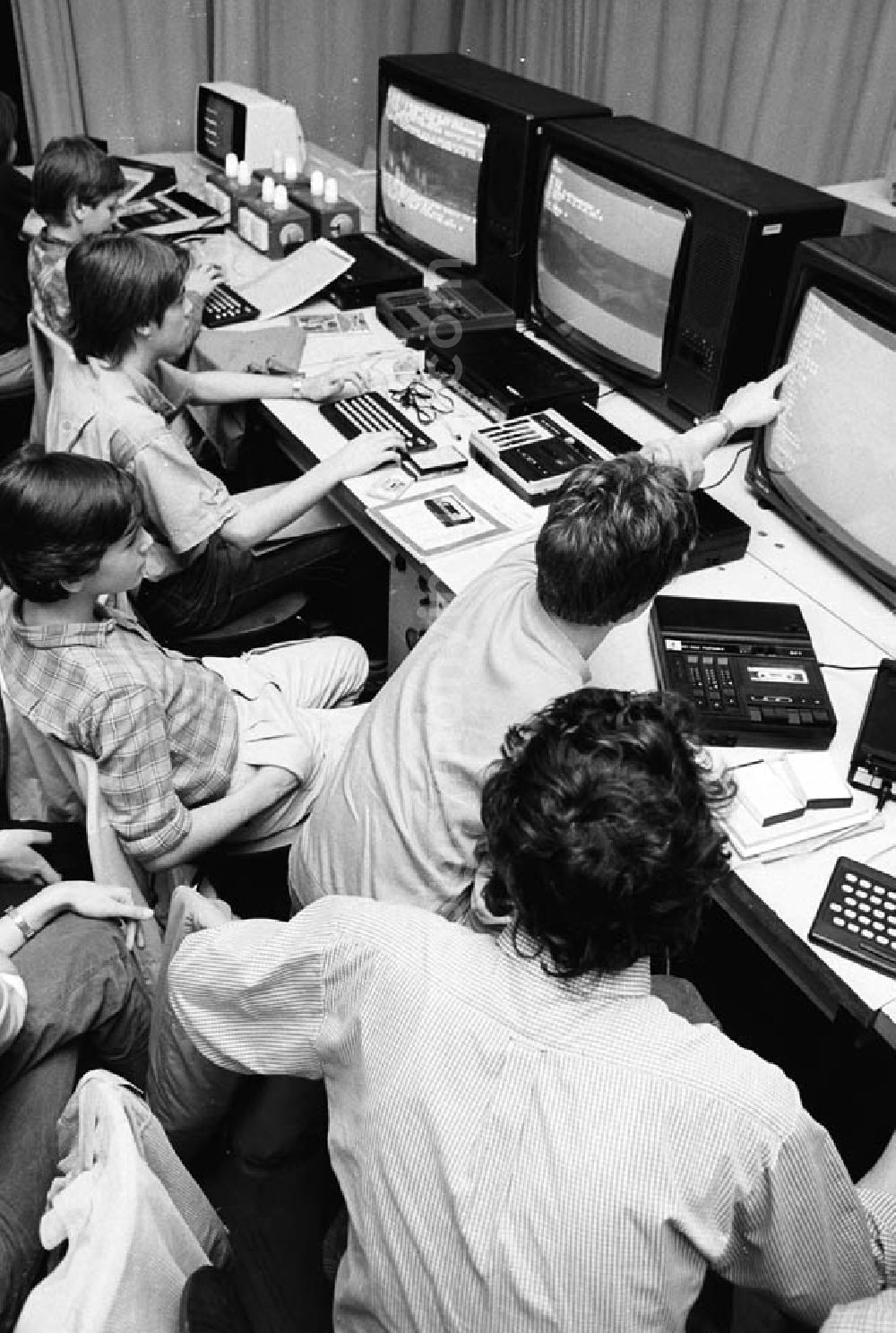 GDR picture archive: - Arbeitsgemeinschaft Monitore im Pionierpalast Ernst Thälmann in der Wuhlheide. Blick von oben auf Kinder sitzen zusammen vor Fernseher / Monitoren / Computer.