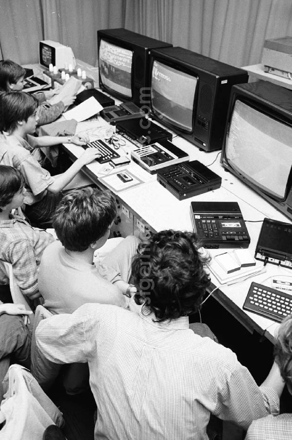 GDR photo archive: - Arbeitsgemeinschaft Monitore im Pionierpalast Ernst Thälmann in der Wuhlheide. Blick von oben auf Kinder sitzen zusammen vor Fernseher / Monitoren / Computer.