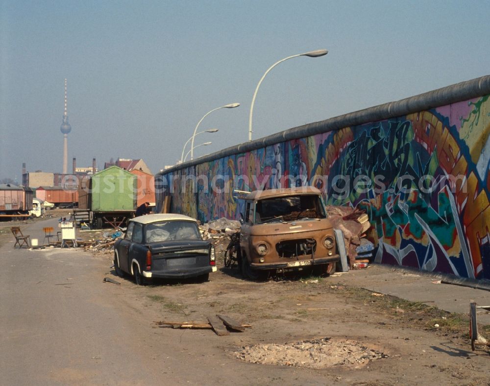 Berlin - Friedrichshain: Two wrecked cars, as well as an illegal garbage dump behind the Berlin Wall in Berlin - Friedrichshain. In the background of the Berlin TV tower and various old Mobile Home