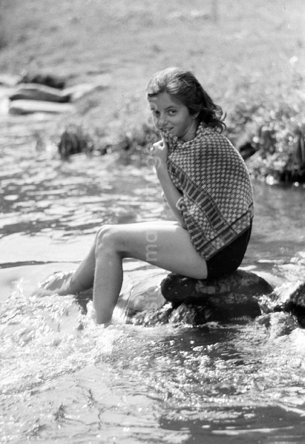 Zschopau: Ein Mädchen sitzt auf einem Stein in dem Fluß Zschopau.