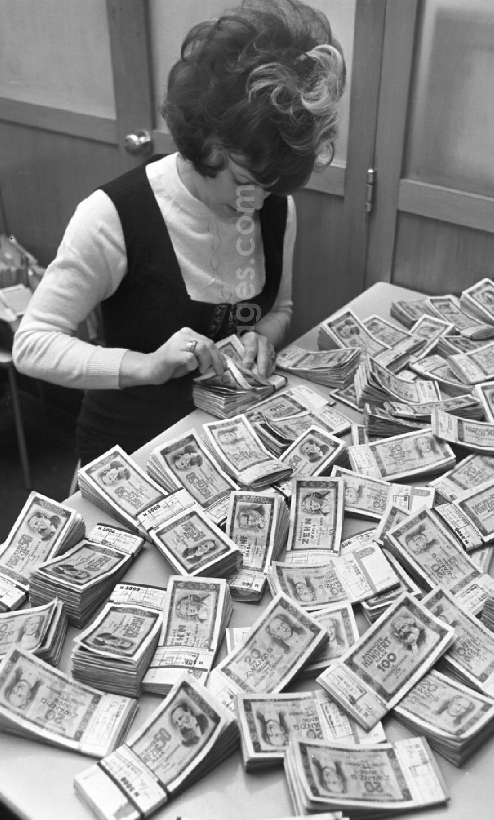 Berlin: Various mark banknotes in stacks on the table of a bank employee as legal tender and currency put into circulation by the state bank in the Mitte district of Berlin, East Berlin in the territory of the former GDR, German Democratic Republic