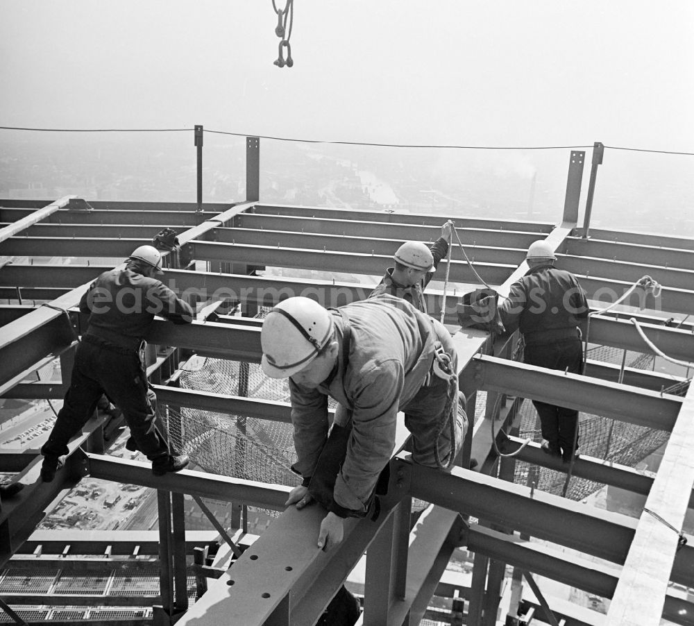 GDR picture archive: Berlin - Construction workers secured with ropes and carabiners during steel girder work on the Berlin TV Tower in the district Mitte in Berlin, the former capital of the GDR, German Democratic Republic