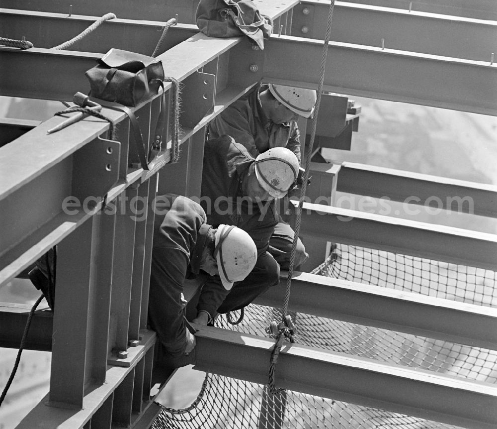 GDR picture archive: Berlin - Construction workers secured with ropes and carabiners during steel girder work on the Berlin TV Tower in the district Mitte in Berlin, the former capital of the GDR, German Democratic Republic