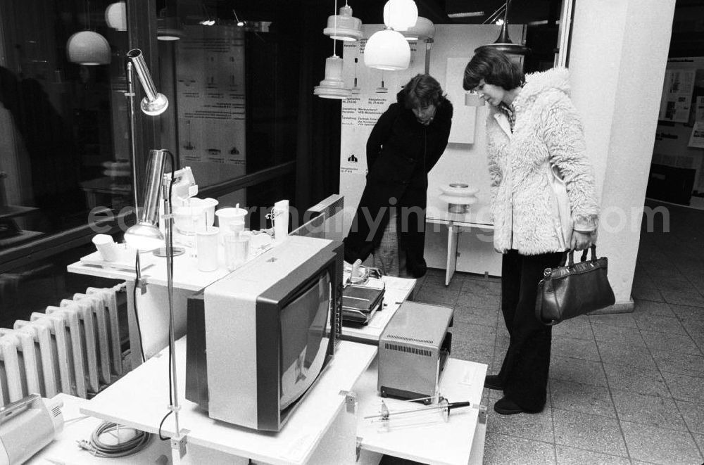 GDR picture archive: Berlin - Zwei Frauen besuchen die Bauausstellung im Ausstellungszentrum am Fuße des Berliner Fernsehturm und betrachten aufmerksam verschiedene elektronische Geräte wie z.B. einen Fernseher.