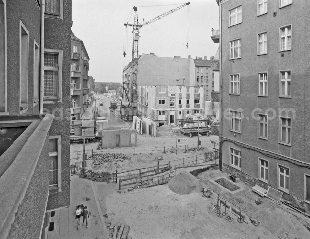 GDR photo archive: Berlin - Construction site for a new building of a prefabricated residential building in a gap in an old building on street Boedikerstrasse in Berlin Eastberlin on the territory of the former GDR, German Democratic Republic