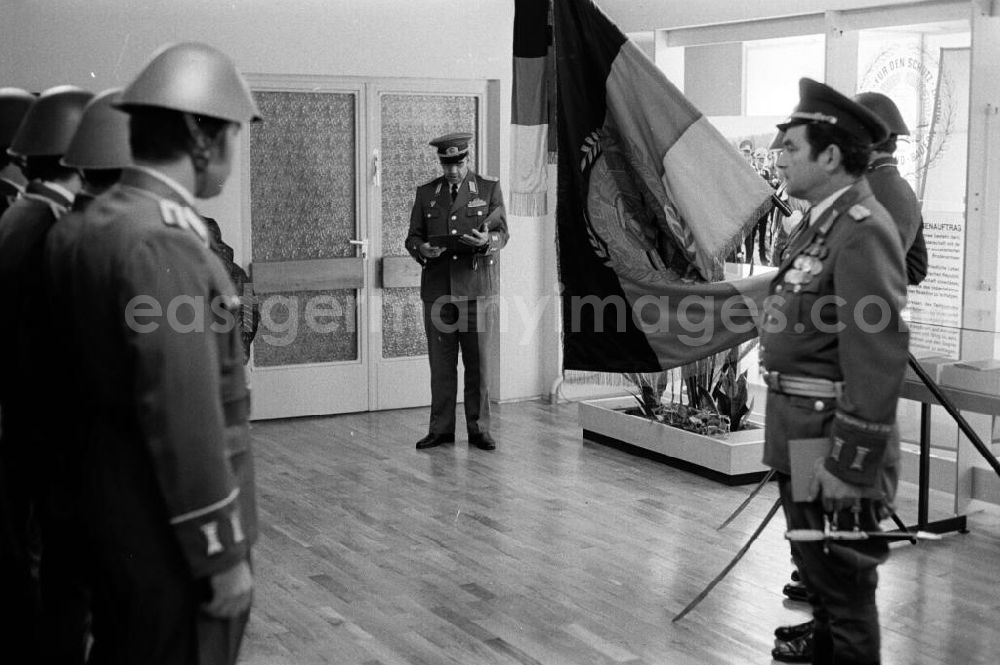 GDR photo archive: Goldberg - Beförderungszeremonie in der Artur-Becker-Kaserne in Goldberg. Soldat hält Flagge / Fahne der DDR.
