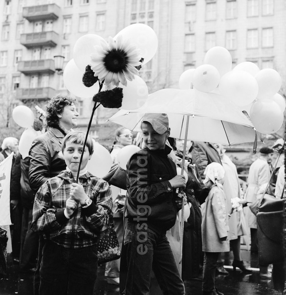 GDR picture archive: Berlin - Enthusiastic GDR citizens with children and family passing by the VIP tribune on 1 May in Berlin, the former capital of the GDR, German Democratic Republic