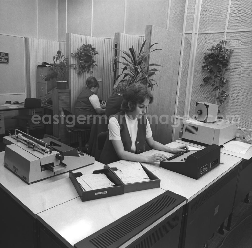 GDR photo archive: Berlin - Eine Frau bei der Arbeit vor einer Rechenmaschine im Büro.