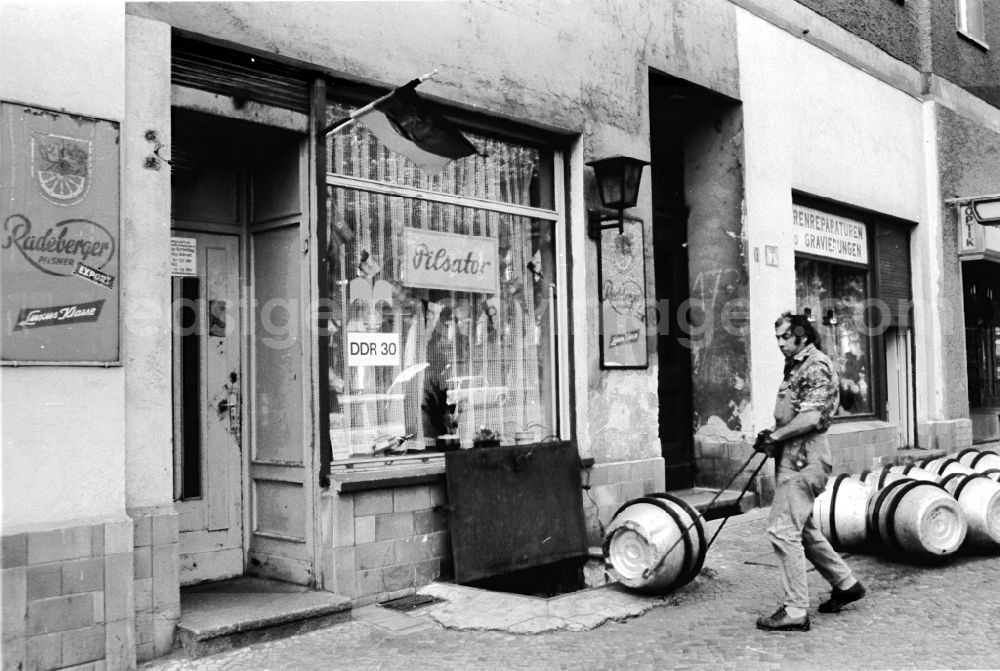 GDR image archive: Berlin - Restaurant and tavern being supplied with aluminum beer kegs by a beer coachman in the beer cellar of a pub in Berlin East Berlin on the territory of the former GDR, German Democratic Republic