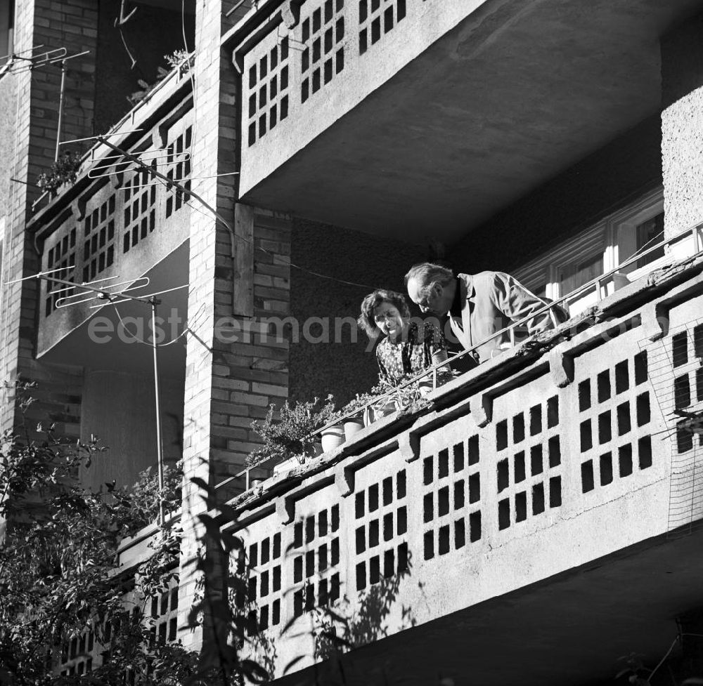 GDR photo archive: Berlin - Ein älteres Ehepaar steht auf dem Balkon seiner Wohnung in Berlin Mitte - während er die Balkonblumen inspiziert, blickt sie interessiert zum Fotografen. Neben den Blumenkästen verzieren Antennen die Fassade der Balkone.