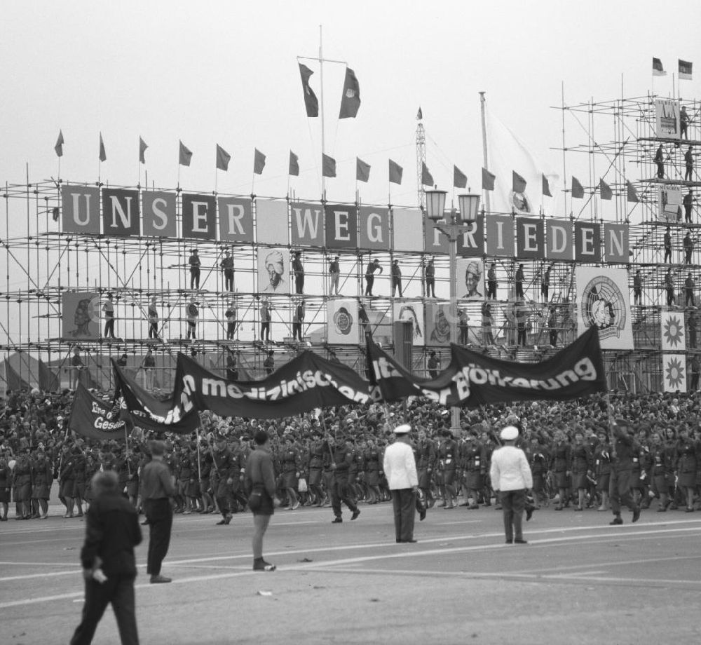 Berlin: Zu Pfingsten 1964, vom 16.-18. Mai, findet in Berlin das letzte Deutschlandtreffen der Jugend für Frieden und Völkerfreundschaft statt, hier Aufmarsch vor der Ehrentribüne auf dem Marx-Engels-Platz (heute Schloßplatz). An dem Gerüst im Hintergrund hängen Motive ost- und westdeutscher Städte und die Losung Unser Weg - Frieden. Ziel der ersten Veranstaltung im Mai 1950 war, die kommunistische Jugend in Ost und West mobil zu machen und der damals in der BRD noch zugelassenen FDJ neue Anhänger zuzuführen. 1951 wurde das Verbot gegen die FDJ in der BRD ausgesprochen. Nach 1964 entsprach eine gesamtdeutsche kommunistische Politik nicht mehr den Zielen der DDR-Regierung. In den 70er und 8