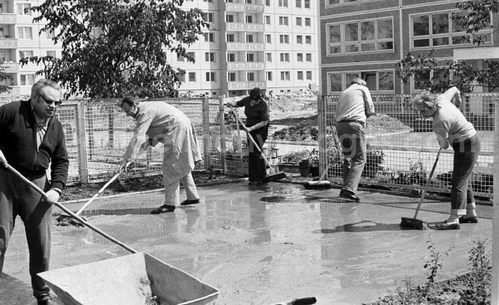 GDR image archive: Berlin - The inhabitants of the recently built development area Marzahn concrete a playing surface before the new kindergarten. Under the slogan Mach mit! GDR citizens were persuaded to do something voluntarily and without pay for the improvement of housing conditions
