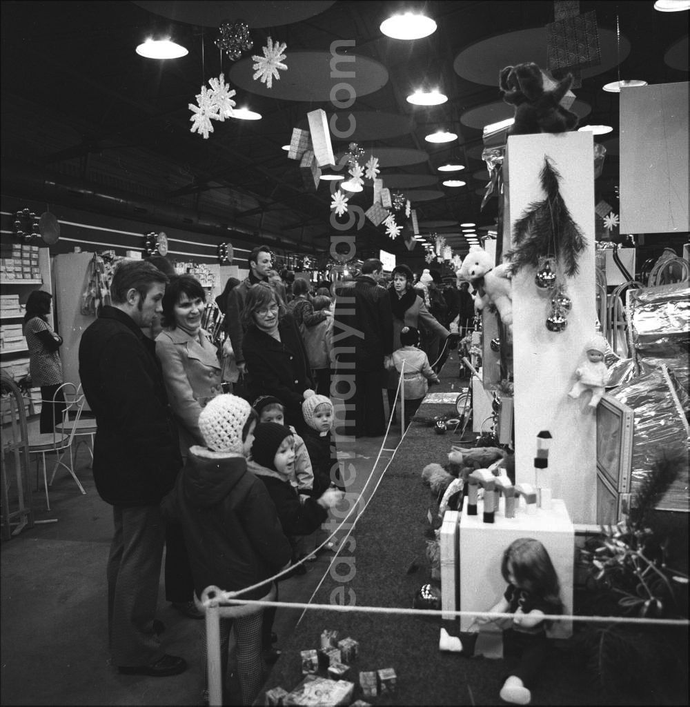 GDR image archive: Berlin Mitte - Großer Andrang auf einem Weihnachtsbaum- und Geschenkbasar in der Adventszeit. Die neuesten Entwicklungen der Spielzeugindustrie ziehen Kinder und Eltern in ihren Bann.