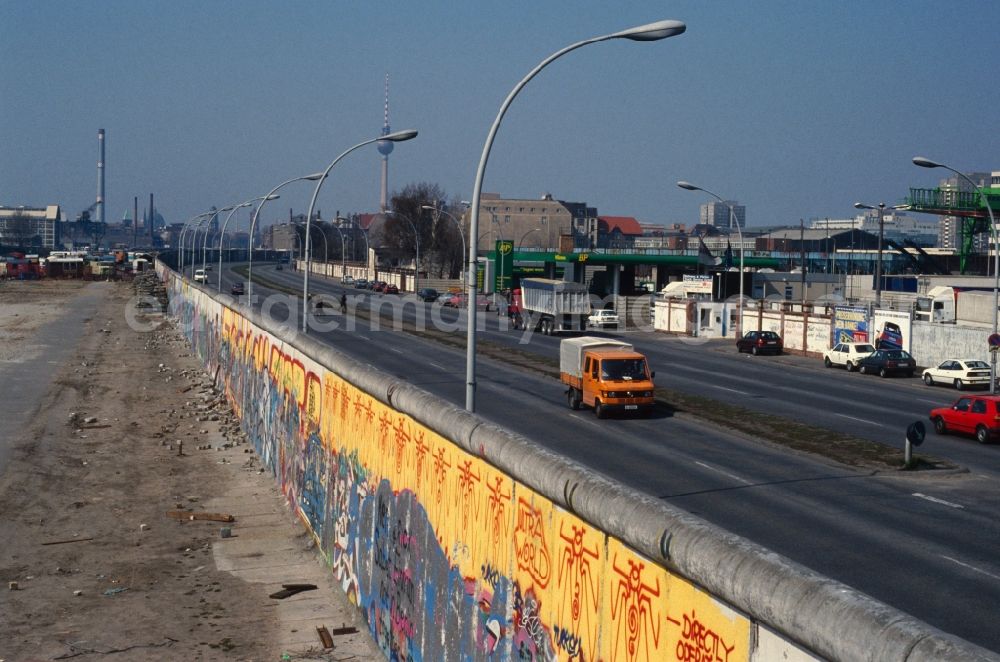 GDR photo archive: Berlin - Friedrichshain - View of the Berlin Wall city inward in Berlin - Friedrichshain. The painted part of the former border installation of the GDR is located in the Stralauer Allee