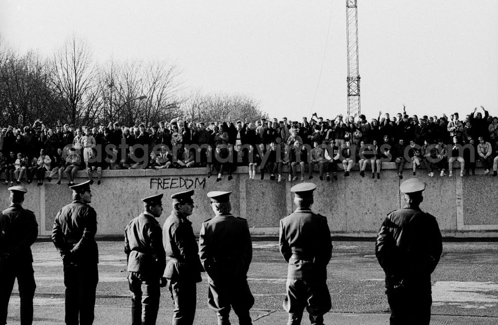 Berlin: Occupation of the tank wall at the front of the Brandenburg Gate in Berlin-Mitte. Several hundred people from West Berlin climbed and occupied the meter-high concrete barriers of the GDR border on the square in front of the Berlin landmark under the eyes of onlookers soldiers of the Border Troops of the GDR