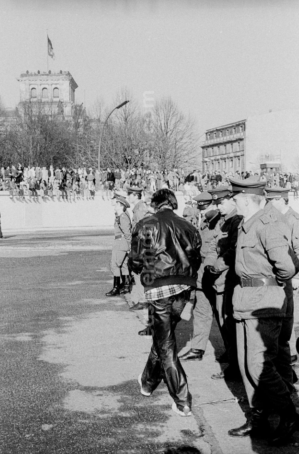 GDR picture archive: Berlin - Occupation of the tank wall at the front of the Brandenburg Gate in Berlin-Mitte. Several hundred people from West Berlin climbed and occupied the meter-high concrete barriers of the GDR border on the square in front of the Berlin landmark under the eyes of onlookers soldiers of the Border Troops of the GDR