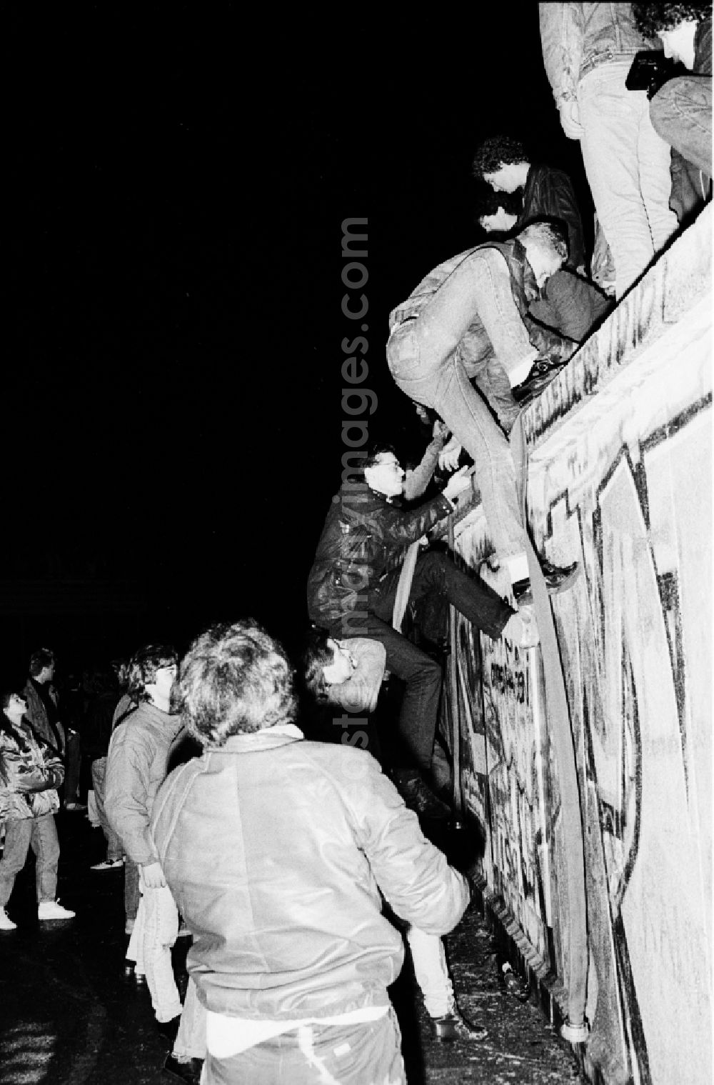 GDR picture archive: Berlin - Occupation of the tank wall at the front of the Brandenburg Gate in Berlin-Mitte. Several hundred people from West Berlin climbed and occupied the meter-high concrete barriers of the GDR border on the square in front of the Berlin landmark under the eyes of onlookers soldiers of the Border Troops of the GDR