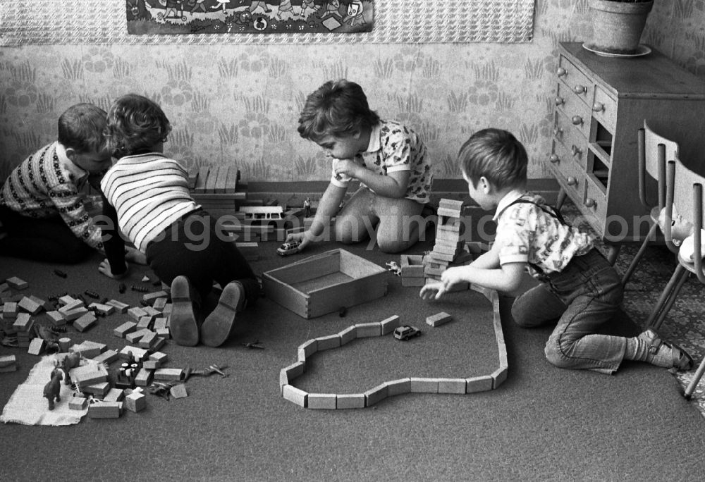 GDR photo archive: Berlin - Games and fun with toddlers in kindergarten playing with wooden blocks in Berlin Eastberlin, the former capital of the GDR, German Democratic Republic