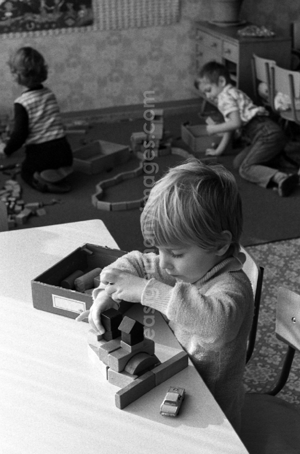 GDR picture archive: Berlin - Games and fun with toddlers in kindergarten playing with wooden blocks in Berlin Eastberlin, the former capital of the GDR, German Democratic Republic