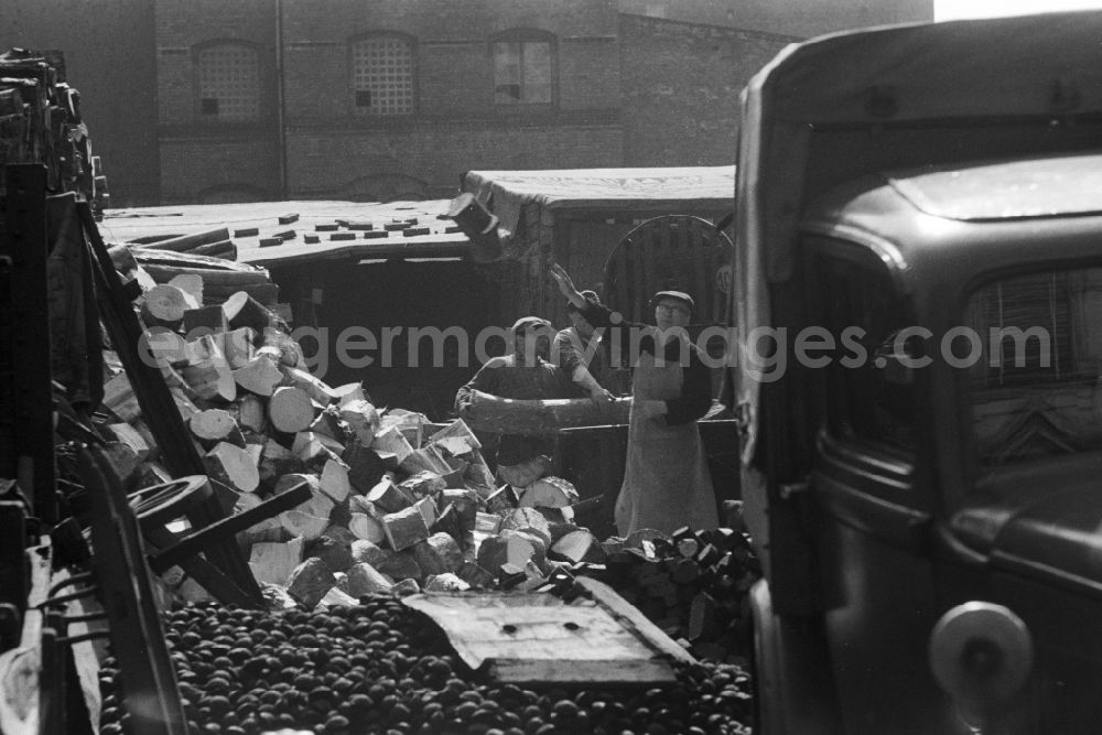 GDR picture archive: Berlin - Employees of a fuel and coal trading company loading firewood, briquettes and so-called egg coal in Berlin, the former capital of the GDR, German Democratic Republic