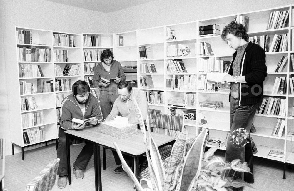 GDR photo archive: Berlin - Blick in die Bibliothek / Freizeitraum des Arbeiterwohnheim an der Rhinstraße / Ecke Landsberger Allee, dem heutigen COMFORT Hotel. Männer sitzen am Tisch bzw. stehen und lesen.